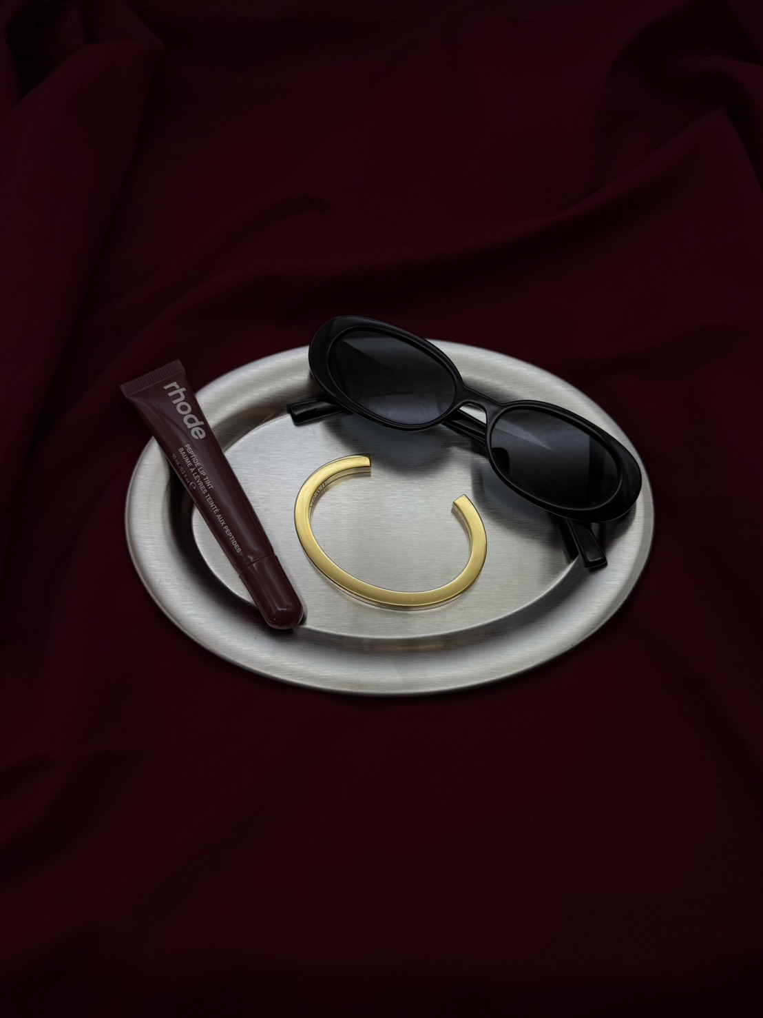Gold VIRAVIE bracelet styled with sunglasses and lip tint