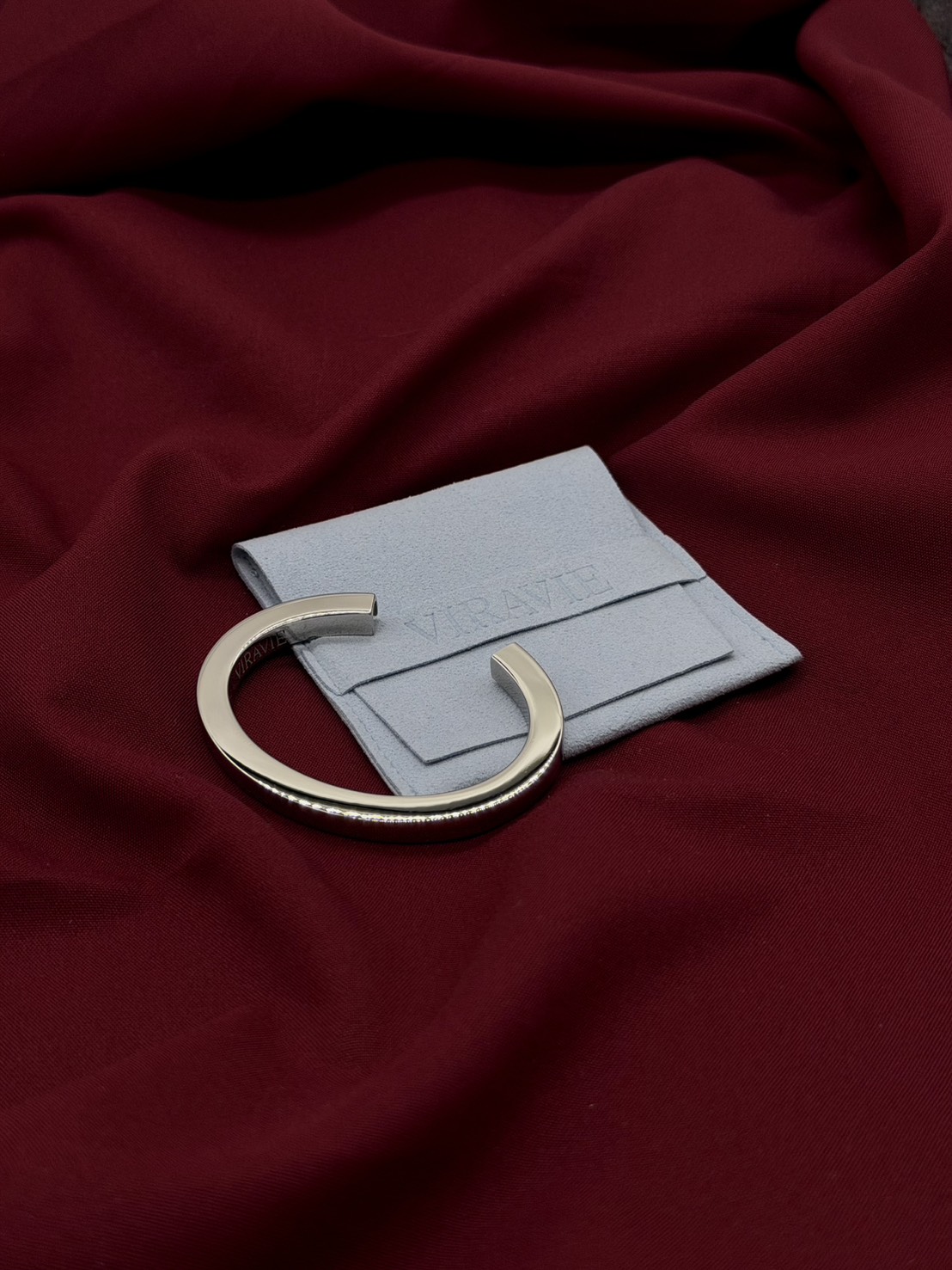 Silver VIRAVIE bracelet with branded pouch and everyday objects